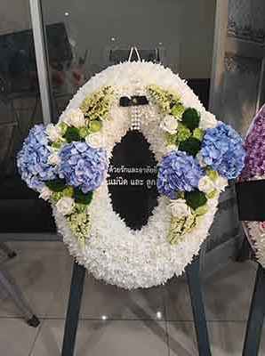 วงรีดอกไม้สดป้ายข้อความตรงกลาง วางในศาลาวัด